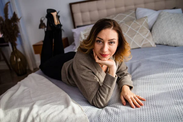 Sakin ve huzurlu orta yaşlı bir kadın, evdeki kanepede bir fincan sıcak çayla dinleniyor. Mutlu, olgun bir bayan eğleniyor ve hayal kuruyor.