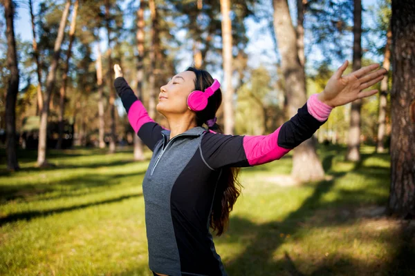 Pretty Young Asian Woman Pink Earphones Preading Her Arms Forest — Stockfoto