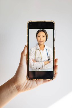 Evde oturan akıllı telefondan Doktor Online 'la görüntülü konuşma. Cep telefonu ekranındaki hekim danışmanı hasta. Uzaktan Uzaktan Tıbbi Danışmanlık Telefon Sohbeti ile. 