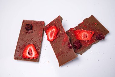 Taze ve kurutulmuş böğürtlenli el yapımı çikolata, ahududu, beyaz arka planda çilek, kırsal tarzda, metin için boş alan.