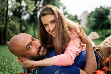 Yaz parkında yeşil çimlere uzanan çift.