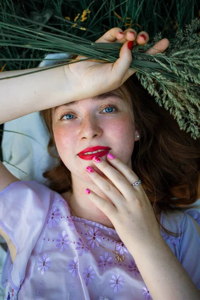 红头发女人 红唇躺在草地上 — 图库照片