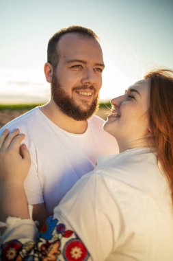 Genç bir çift gün batımında lavanta tarlasında birbirlerine sarılıyorlar.