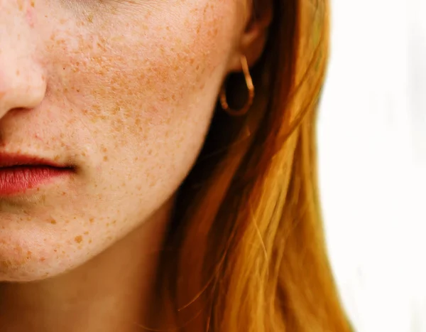 Close-up face of a young ginger ginger freckled woman with red hair and perfect healthy freckled skin isolated on white background.