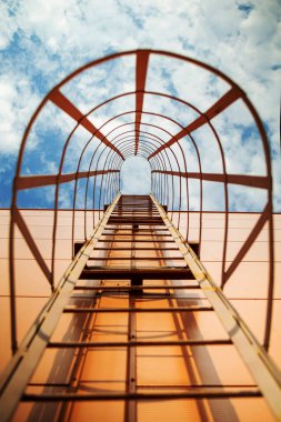 Red iron steps leading to the blue sky