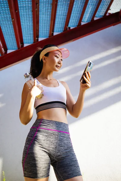 Fitness Concept Happy Asian Woman Holding Water Bottle Using Smartphone — Stockfoto