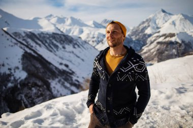 Young hiker man Standing On Top Of Mountain admiring the view During Winter holidays. sport, travel and technology concept.