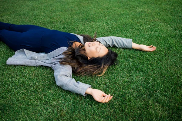 生命的平衡 年轻的亚洲女人紧闭双眼躺在草地上 — 图库照片