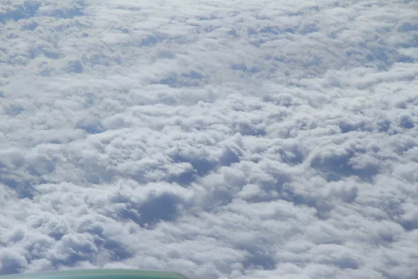 Пушистые белые облака из окна самолета — стоковое фото