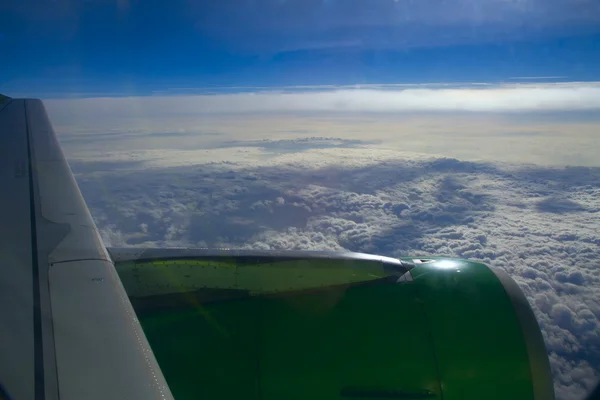 Крыло самолета на фоне облаков из окна. Синий ск — стоковое фото