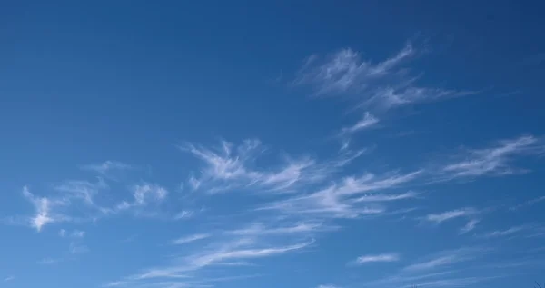 Kabarık beyaz bulutlu parlak mavi gökyüzünün yatay görüntüsü..