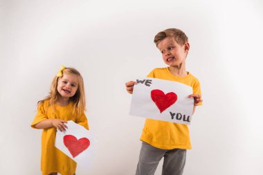 Mutlu küçük oğlan ve kız ellerinde beyaz tahta ile çizim yapıyorlar