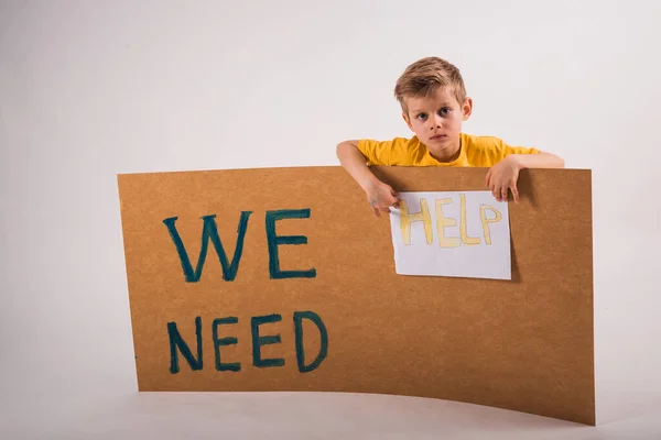 Necesitamos Ayuda Pequeño Infeliz Chico Sosteniendo Tablero Con Palabras Que — Foto de Stock