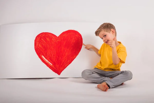 Niño Feliz Está Sentado Suelo Junto Hay Gran Rojo — Foto de Stock