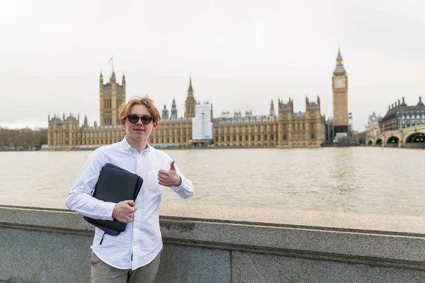 ロンドンのノートパソコンを持つ学生が川沿いに立ち — ストック写真