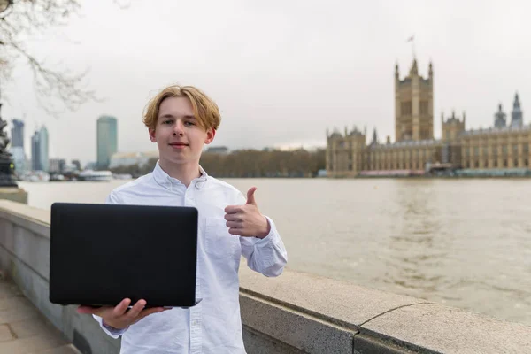 ロンドンでノートパソコンを持つ幸せな少年 カメラを見て — ストック写真