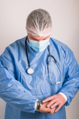 Tıp üniforması giyen yakışıklı doktor. Zamanı kontrol ediyorum.