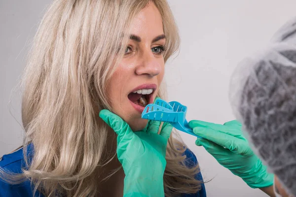 dentist using dental impression tray on woman teeth