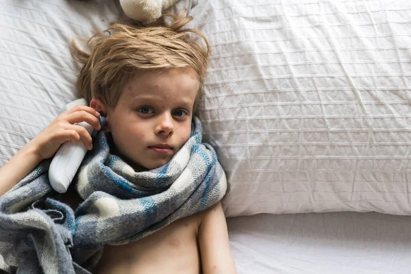 6 yaşında yatakta yatan bir çocukta suçiçeği. Portre, uzun saç