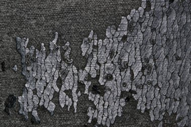 Yıpranmış ve çıplak siyah vinil döşeme parçaları bir sandalyede. Doğrudan yukarıdan görüldüğü gibi yakın plan.