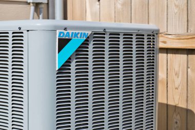 Houston, Texas USA 08-08-2022: Daikin air conditioner unit, corner view at eye level with logo and wooden fence in the background.