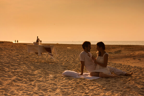 young couple in love sitting on the beach