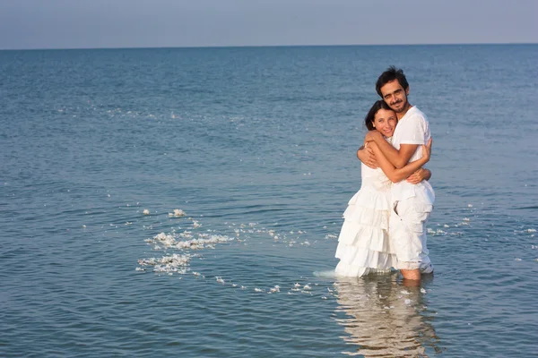 Pareja joven en ropa blanca en el mar —  Fotos de Stock