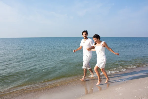 Young couple running on a tropical beach — Stock Photo, Image