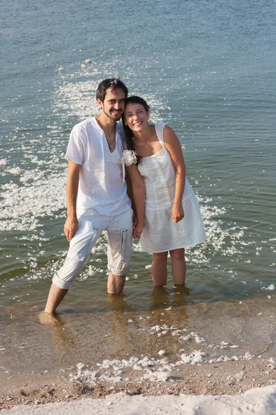 Pareja joven de pie en el mar y riendo después de las almohadas de lucha —  Fotos de Stock