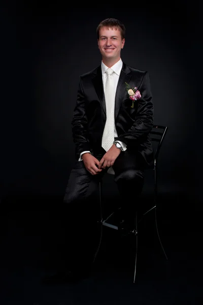 Lächelnder Mann im Studio auf schwarzem Hintergrund — Stockfoto