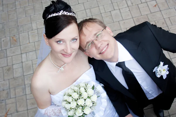 Cute young bride and groom looking up — Stock Photo, Image