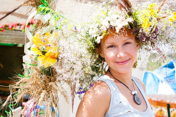 Giovane donna sorridente con fiori estivi corona sulla testa — Foto Stock