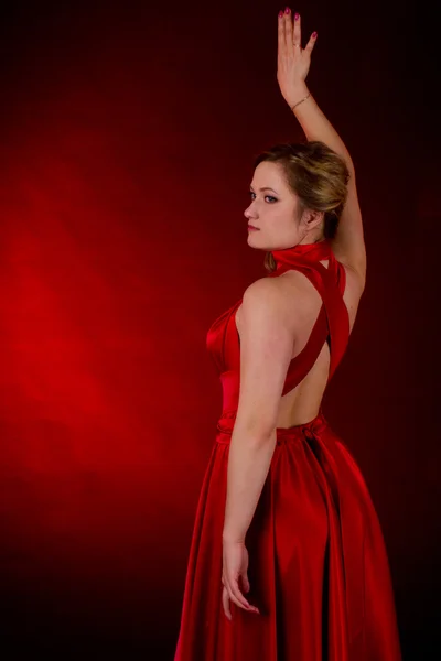 Young beautiful girl in a red dress on a red background — Stock Photo, Image