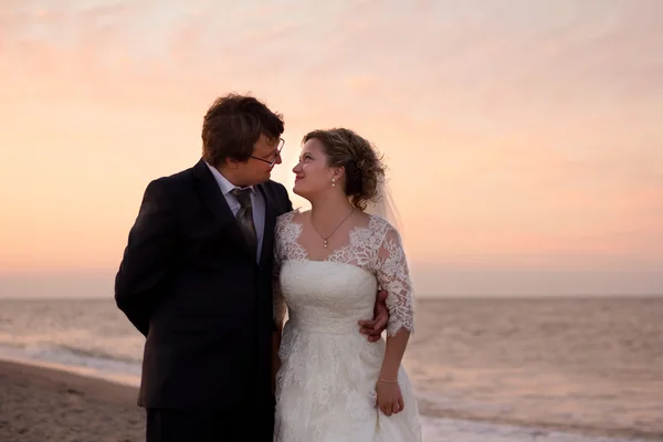 Vrolijke echtpaar staande op het strand — Stockfoto