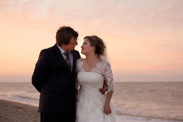 Cheerful married couple standing on the beach — Stock Photo, Image