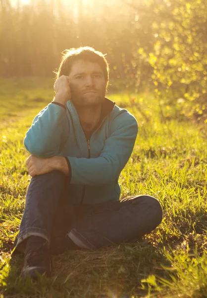 Man zit op gras en gebruik mobiele telefoon — Stockfoto