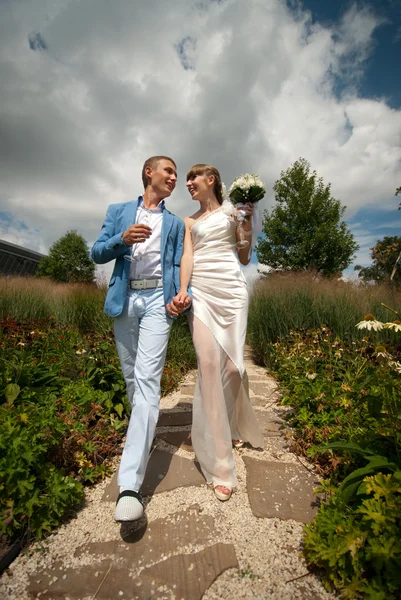 Bruden och brudgummen gå iväg medan du håller händerna — Stockfoto