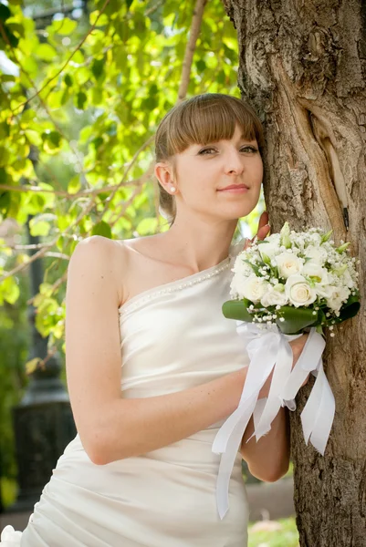 Beautiful bride laughs about wood — Stock Photo, Image