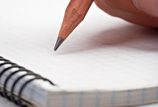 Scrivere su un blocco note con una matita — Foto Stock