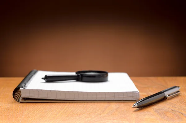 Notebook, pen and magnifier — Stock Photo, Image