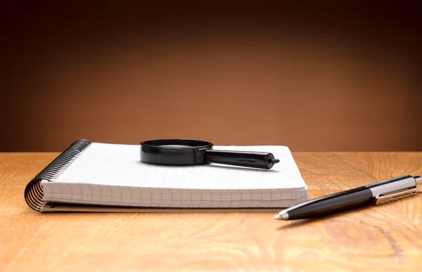 Notebook, pen and magnifier — Stock Photo, Image