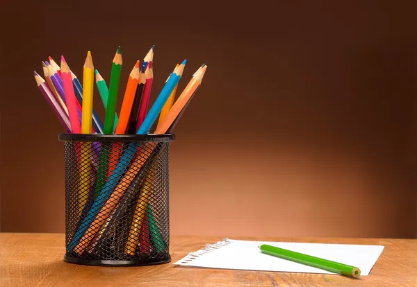 Blank sheet of paper and colored pencils on a wooden table — Stock Photo, Image