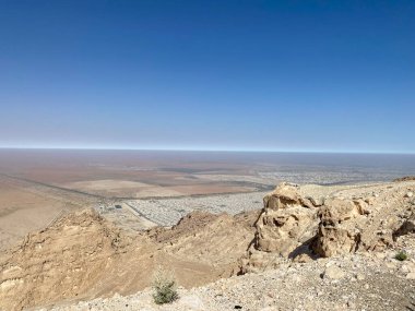 Jebal Hafeet 'den Al Ain, Abu Dabi, Birleşik Arap Emirlikleri 'nin görünümü kırmızı, turuncu ve sarı kuma bakıyor.