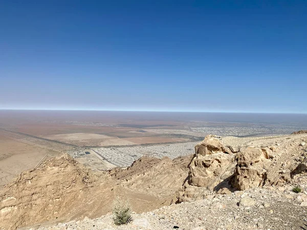 Jebal Hafeet 'den Al Ain, Abu Dabi, Birleşik Arap Emirlikleri 'nin görünümü kırmızı, turuncu ve sarı kuma bakıyor.