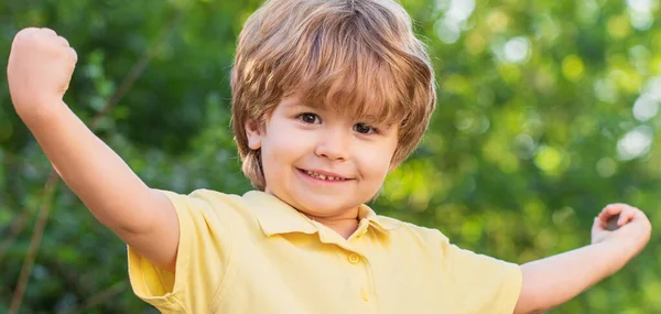 Niño sonriente. Alegre niño alegre. Niños felices niño con las manos arriba. Niño al aire libre en la naturaleza. Feliz niña. Niño divertido aislado sobre un fondo de árboles verdes —  Fotos de Stock