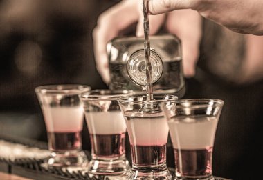 Gece kulübünde fondip. Bardakta kırmızı alkolik içkisi. Gece kulübünde kırmızı kokteyl. Barmen kokteyl hazırlıyor.