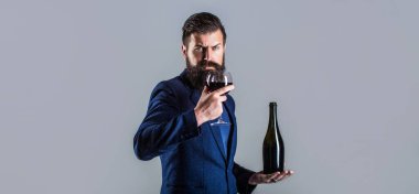 Şişede kırmızı şarap, şarap kadehi. Sommelier adam, degustator, şaraphane. Şampanya ve şarap taşıyan bir adam. Şişe, kırmızı şarap kadehi. Sakallı, sakallı, şarap garsonu.