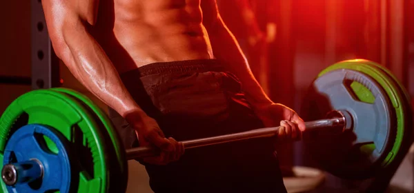 Ο αθλητικός τύπος σηκώνει το κουδούνι στο γυμναστήριο. Closeup deadlift barbells γυμναστική.Workout το γυμναστήριο. Αθλητικός με εξάδα κοιλιακούς. — Φωτογραφία Αρχείου