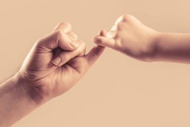 İki elin serçe parmağı birbirine tutunur. Dostluk ve bağışlayıcılık göster. Nesillerdir dostuz. Baba, kız el dostluk sözü veriyor. Çocuk küçük parmağını birbirine bağlar.