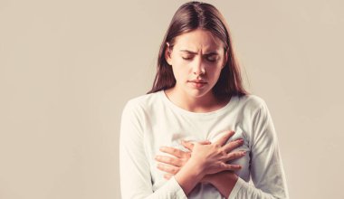 Göğüs ağrısı çeken bir kadın. Kalp krizi geçiren bir kadın. Kalp krizi konsepti. Kalp ağrısı çeken ve göğsünü tutan bir kız. Sağlık ve tıbbi konsept. Göğüs ağrısı çeken bir kız.